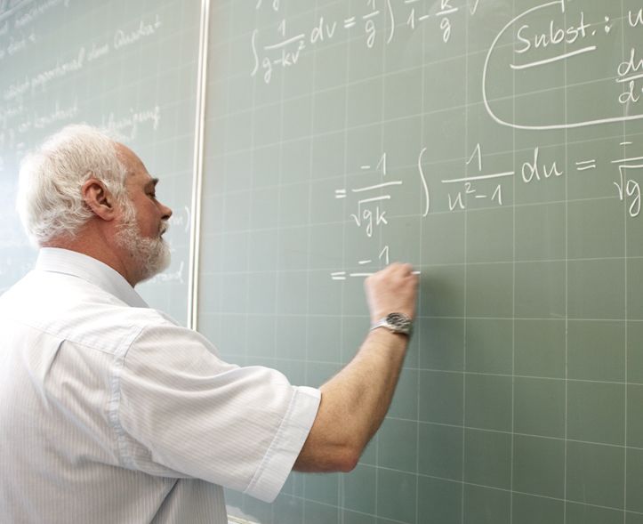 Ein Professor schreibt eine mathematische Gleichung an die Tafel