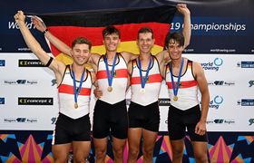 Das Foto zeigt die vier glücklichen Ruderer mit der Deutschlandflagge bei der Siegerehrung