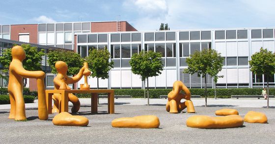 Forum / Campus mit gelben Skulpturen und Gebäude G im Hintergrund