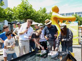 Das Bild zeigt zwei Teams und ihre Solarboote kurz vor dem Start. Die Boote liegen im Wasser und warten darauf loszufahren