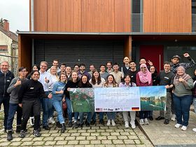 Gruppenbild der Teilnehmenden, die ein Banner mit dem Spring School Titel halten