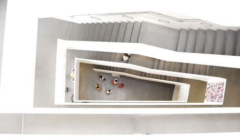 Bird's-eye view of students in an asymmetrical stairwell.
