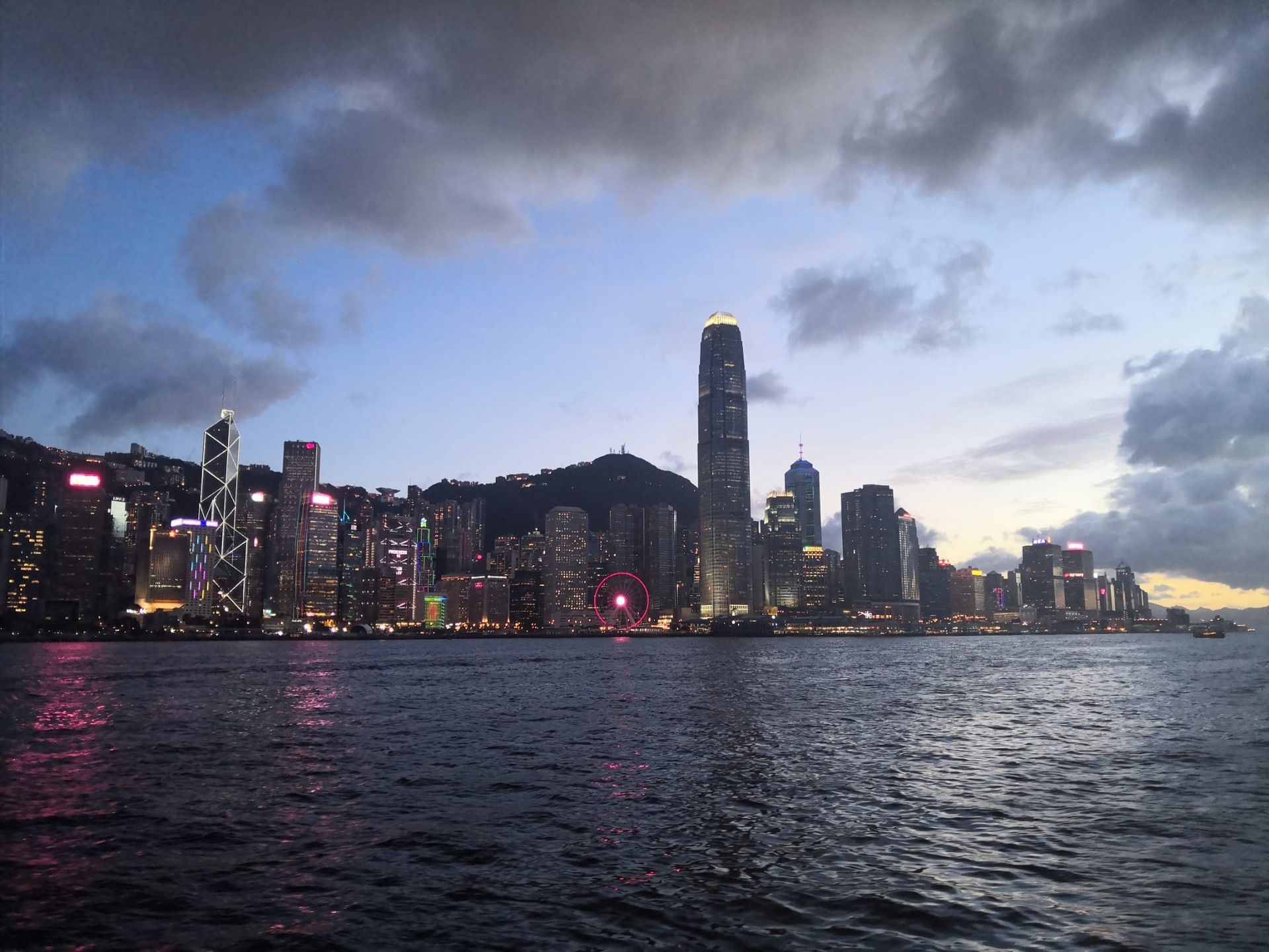 Die Skyline von Hongkong bei Dämmerung vom Wasser aus betrachtet.