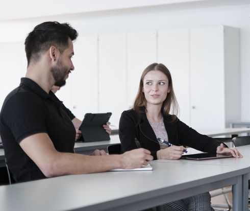 Ein Student und eine Studentin während der Lehrveranstaltung bei einer Teamarbeit.