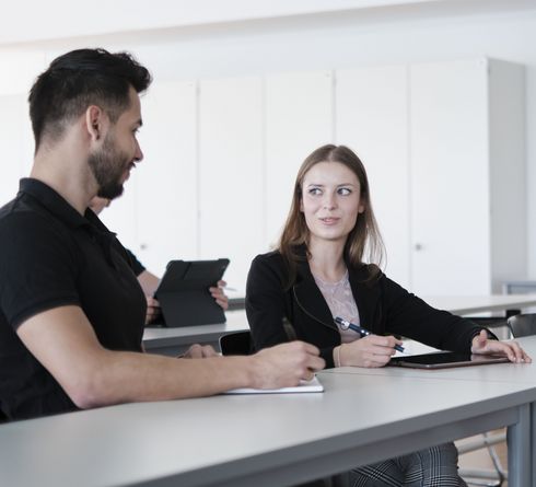 Ein Student und eine Studentin während der Lehrveranstaltung bei einer Teamarbeit.