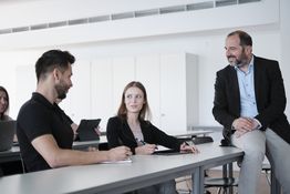 Situation während einer Lehrveranstaltung. Zwei Studierende im Austausch mit Prof. Dr. Erdal Yalcin.