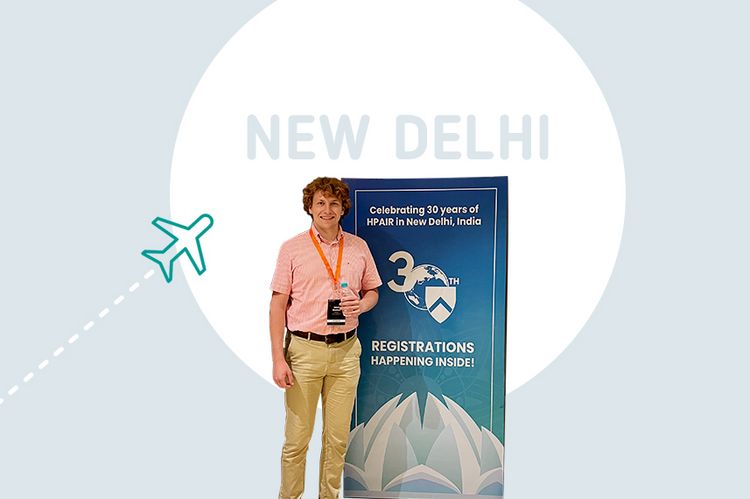 HTWG-Student Jakob Nischan steht neben einem Aufsteller der HPAIR in Neu Delhi, zu der er mit einem Reisestipendium anreiste.