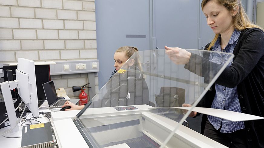 2 Studentinnen arbeiten an einem Laserschneider