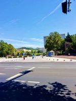 Eine weite, leere Straße auf dem Campus der Qingdao Universität an einem sonnigen Tag mit strahlend blauem Himmel. 