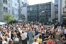Das Bild zeigt eine große Gruppe von Menschen im Innenhof der Hochschule. Sie unterhalten sich ausgelassen auf einem Fest bei gutem Wetter.