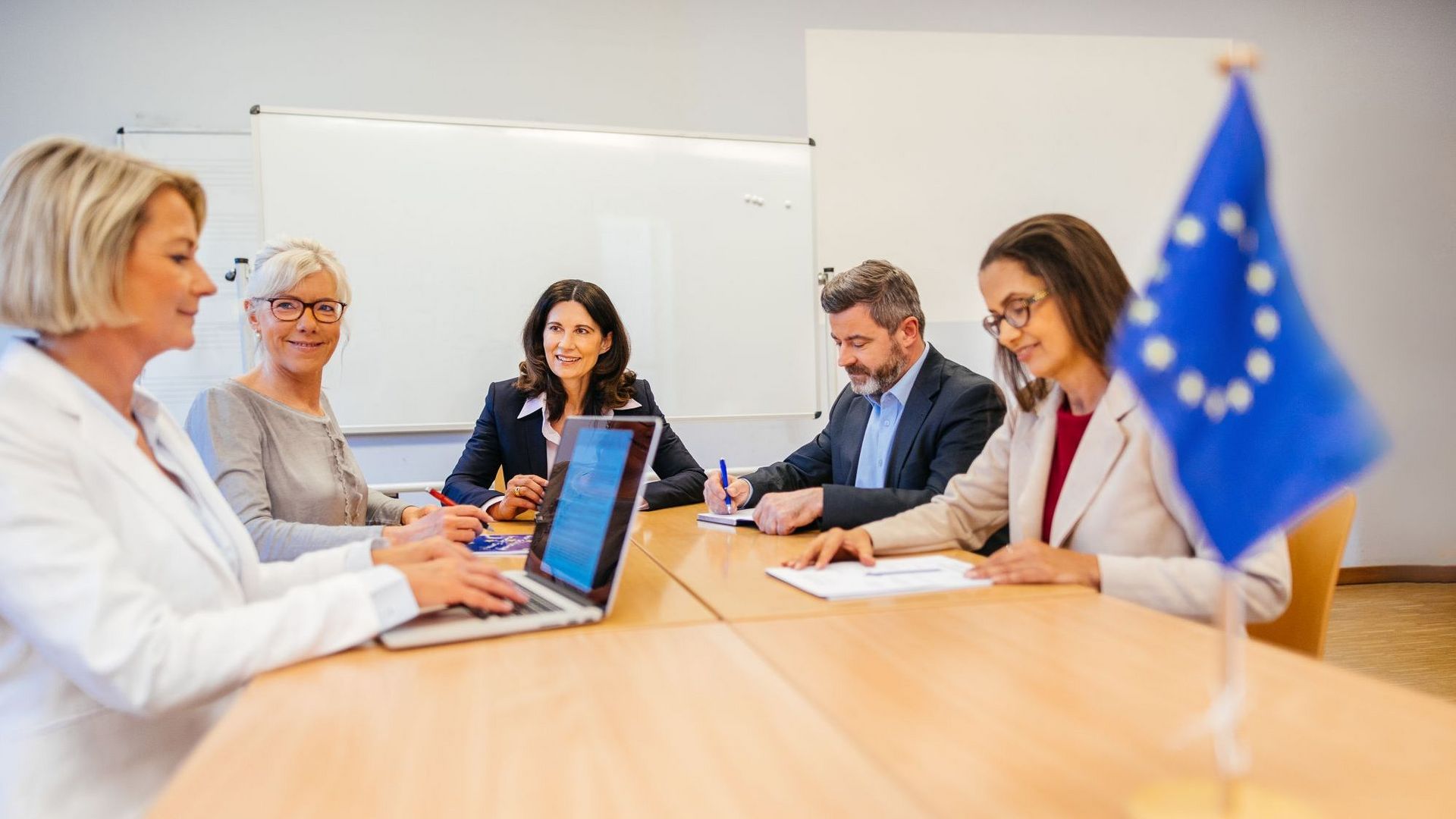 Eine Gruppe von Hochschulmitarbeitern unterhalten sich an einem großen Tisch