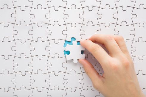 Das letzte, weiße Puzzleteil wird gerade in ein Puzzle eingefügt.