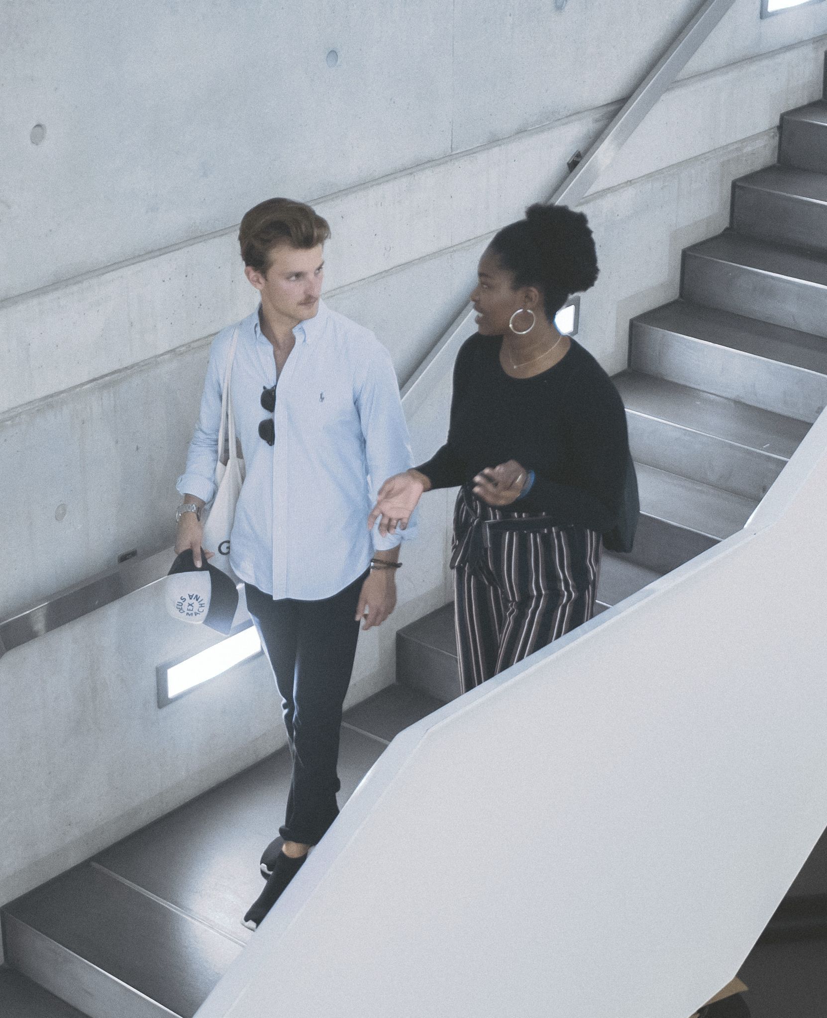 Zwei Studierende unterhalten sich auf einer Treppe in der Hochschule