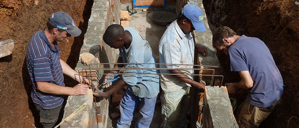 Vier Ingenieure arbeiten am Fundament eines Brückenpfeilers.