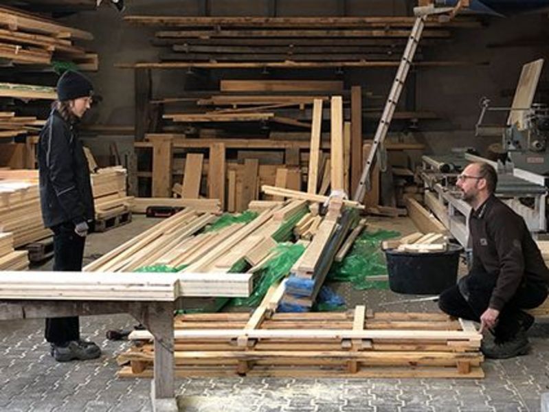 Eine Freiwillige (FSJ) und Schreiner helfen beim Bau.