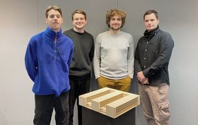 Gruppenaufnahme des Gewinner-Teams der HTWG. Im Vordergrund steht auf Hüfthöhe das Holzmodell eines Architekturentwurfs. Von links nach rechts: Jan Schreiber, Adrian Stibi, Felix Daumüller und Dominik Pelz. 