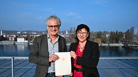 Ein Mann und eine Frau stehen auf einer Dachterasse 