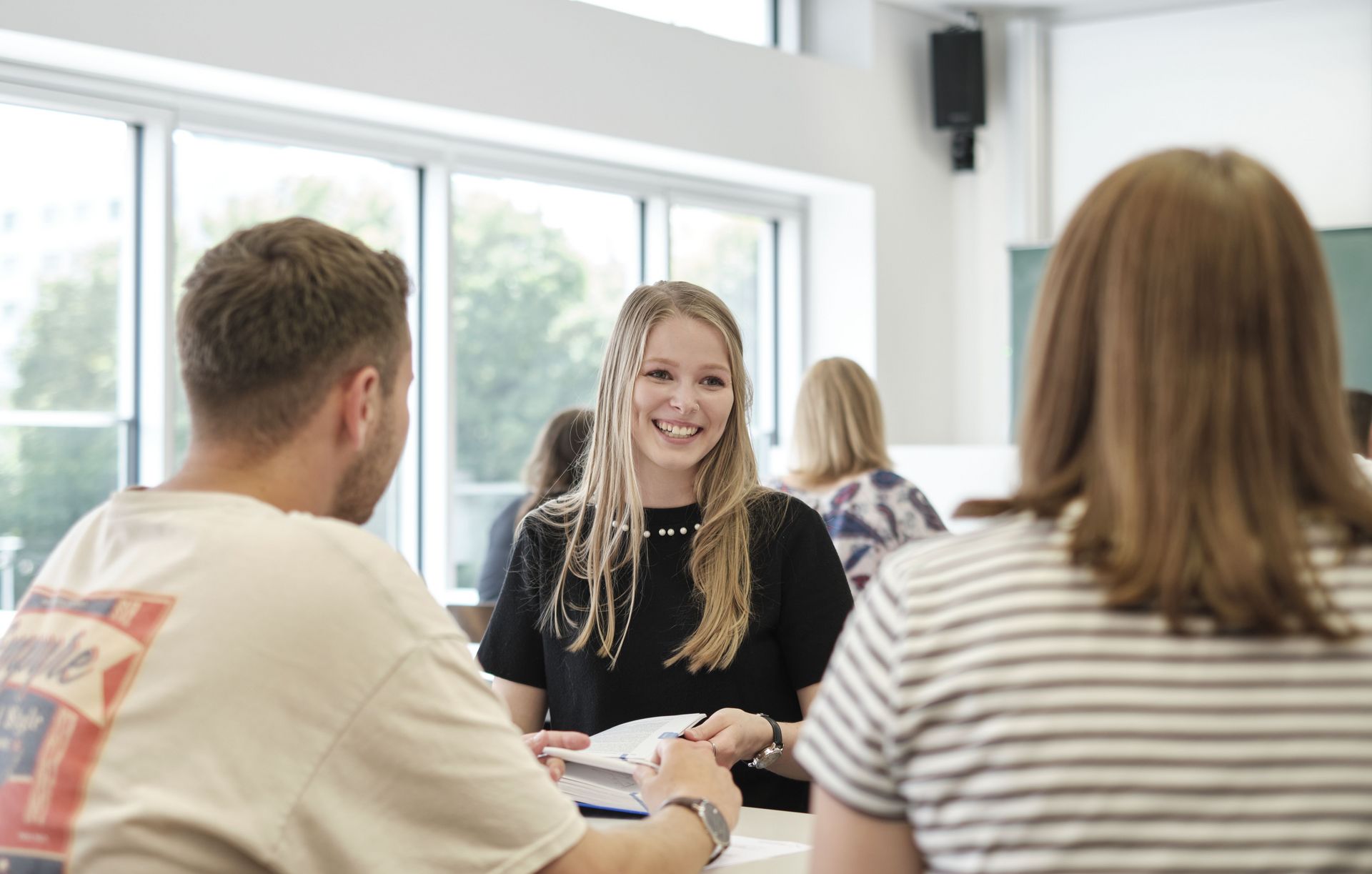 Schüler*innen sitzen zusammen im Klassenraum und unterhalten sich