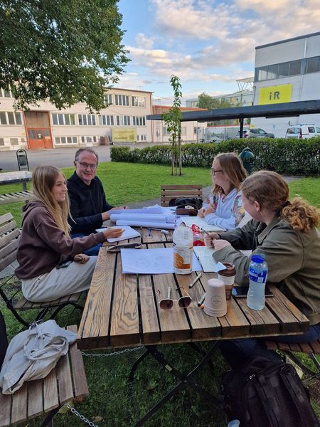 Tischbesprechung mit Studentinnen und Prof. Herr Schenk im Innenhof des Bürkle-Areals.