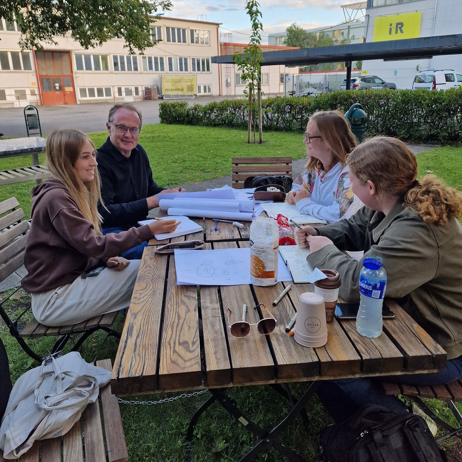 Tischbesprechung mit Studentinnen und Prof. Herr Schenk im Innenhof des Bürkle-Areals.