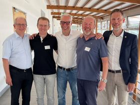 Fünf Männer lachen freundlich in die Kamera