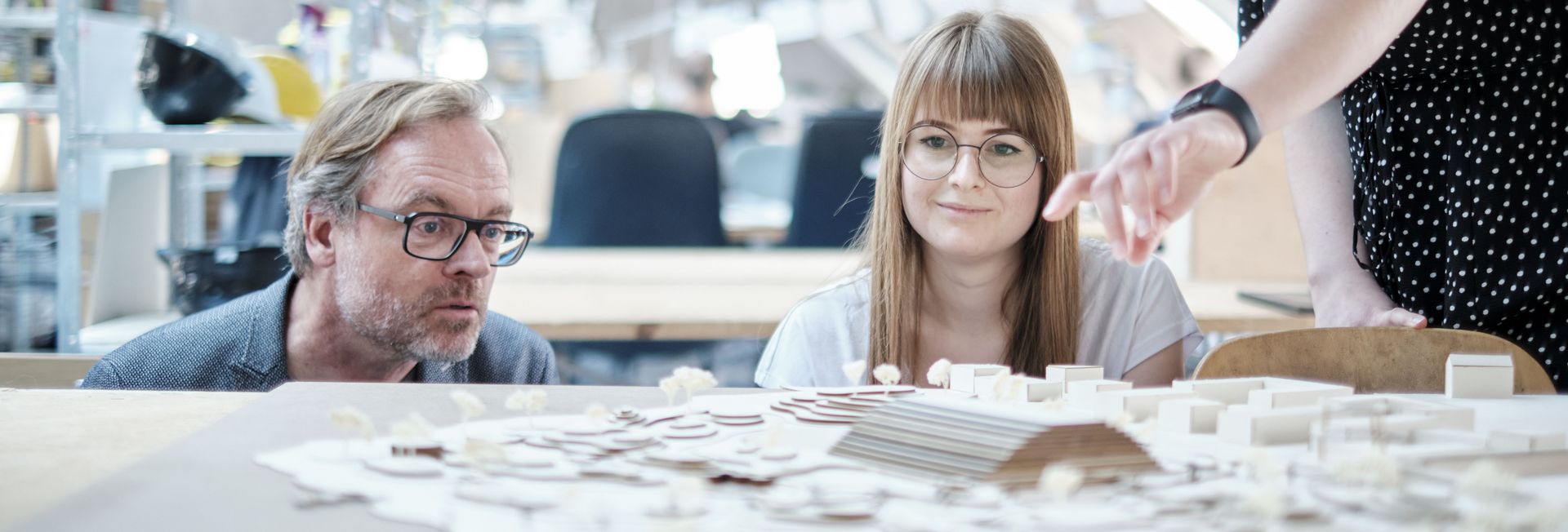 Auf em Foto Stehen Studierende und ein Lehrender um ein Stadtmodell