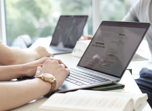 Anonyme Situation: Hände zweier Studierender, die an ihren Laptops arbeiten.