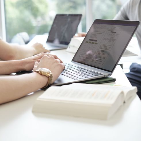 Anonyme Situation: Hände zweier Studierender, die an ihren Laptops arbeiten.
