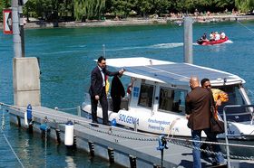 Das Forchungsboot Solgenia der HTWG ankert vor einem Steg am Seerhein. Drei Männer befinden sich auf dem Steg. Einer steht auf dem Boot.