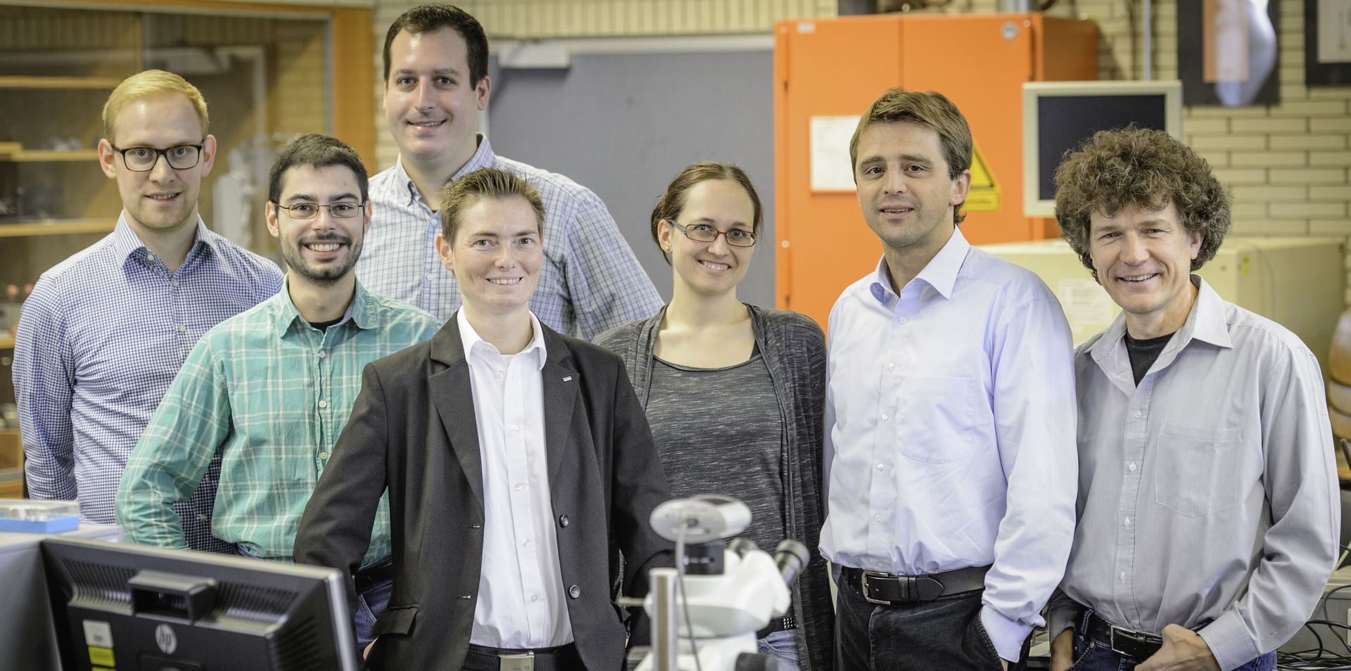 Gruppenfoto 7 Personen lachen den Betrachter an