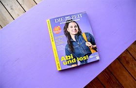 Der Zeitstudienführer liegt auf einer lilafarbenen Holzfläche