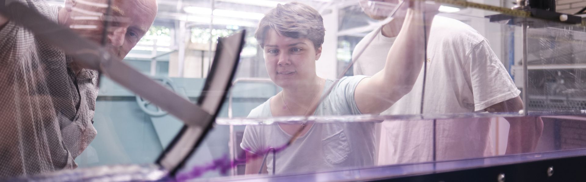 Eine Studentin spritzt Farbe in eine Strömungsrinne um das Strömungsverhalten zu prüfen.