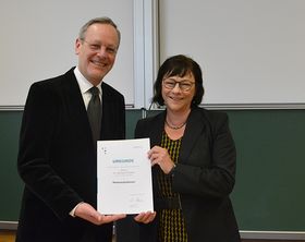 Ein Mann und eine Frau halten gemeinsam eine Urkunde in den Händen 