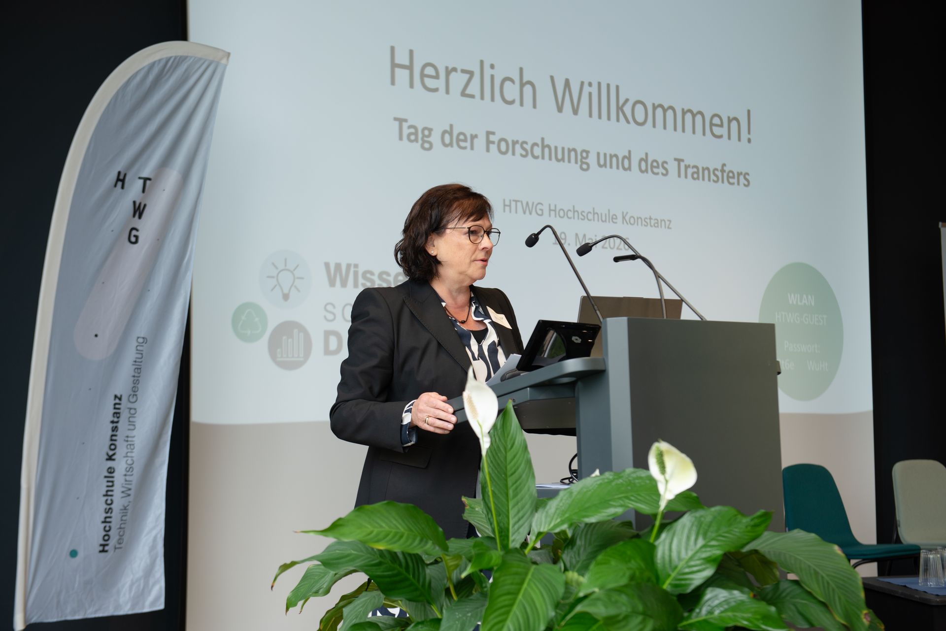Präsidentin Prof. Dr. Sabine Rein steht vor einem Redepult und hält eine Begrüßungsrede.