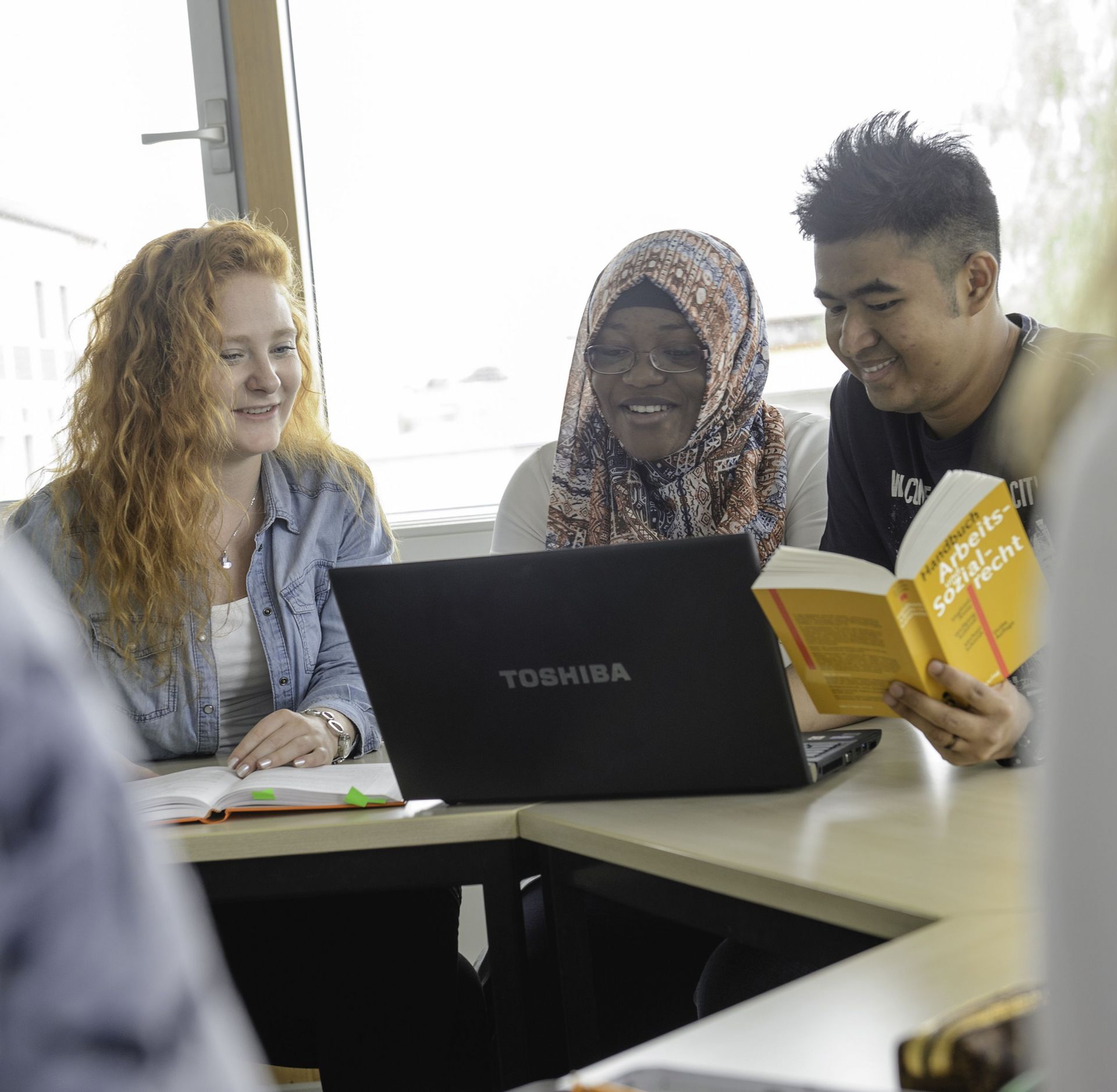 Studierende unterschiedlicher Herkunft arbeiten an einem Projekt