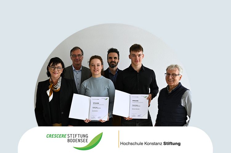 Eine sechsköpfige Gruppe Menschen. Eine junge Frau und ein junger Mann stehen in der Mitte und halten stolz ihre Stipendiumsurkunde in den Händen.