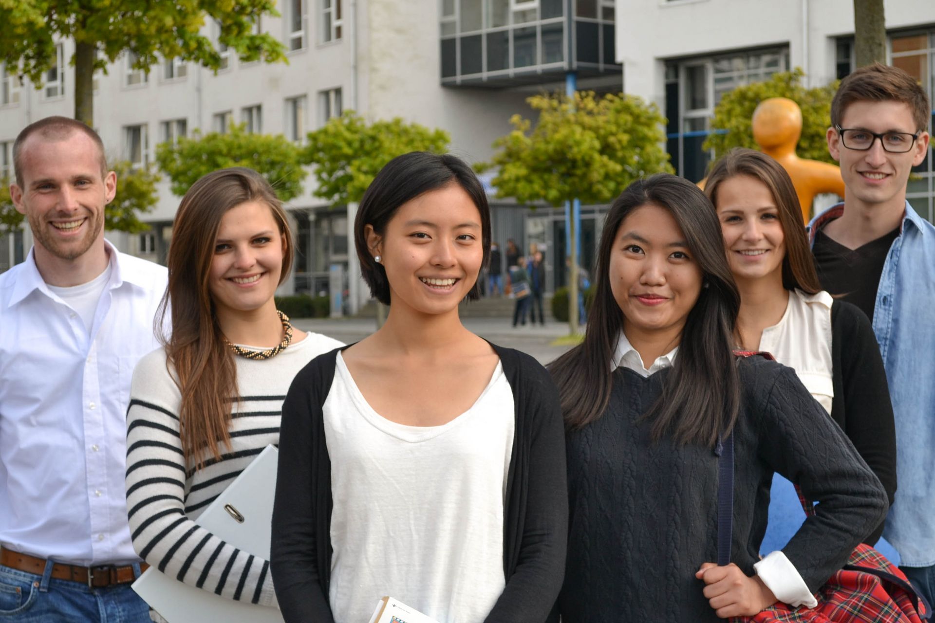 Eine Gruppe von Studierenden unterschiedlicher Nationalität stehen im Innenhof der HTWG und schauen lächelnd frontal in die Kamera