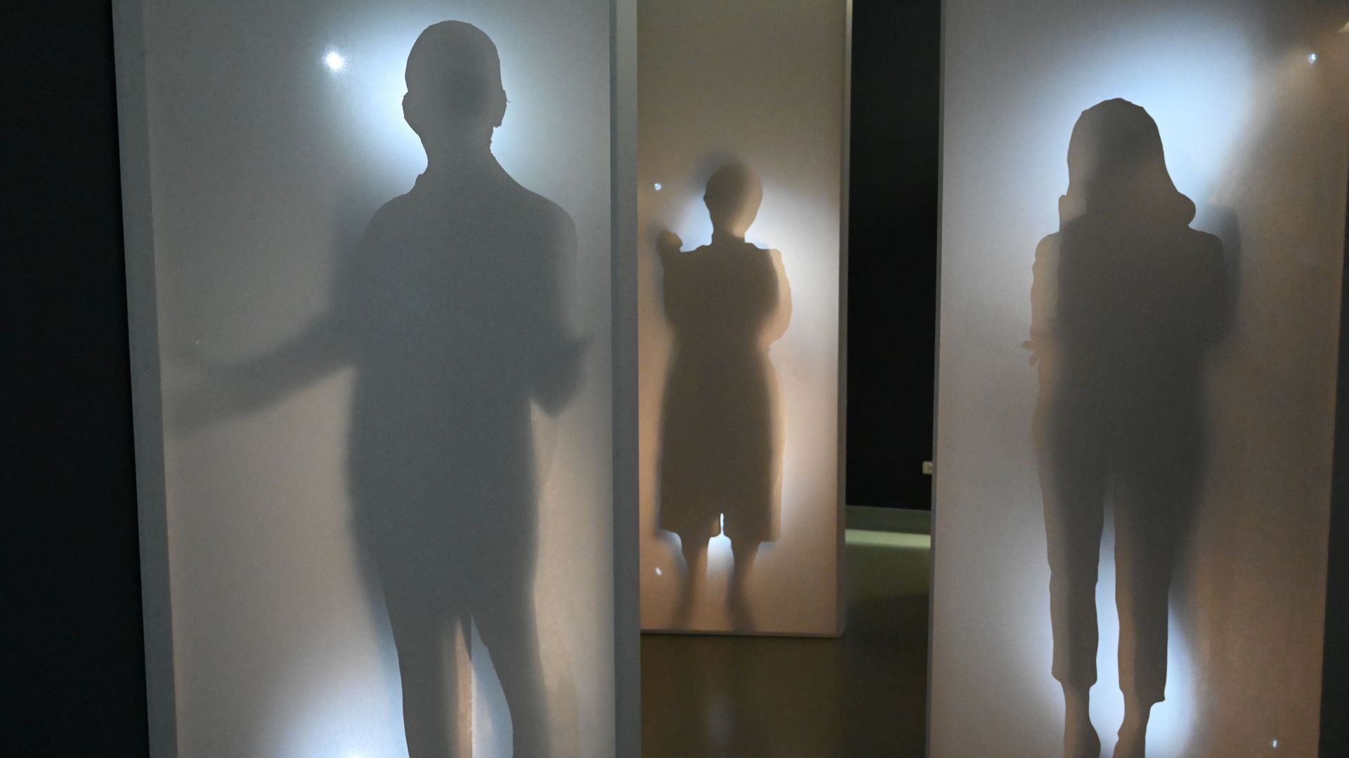 Foto aus der Ausstellung "Ankommen", zu sehen sind Schattenrisse von Menschen