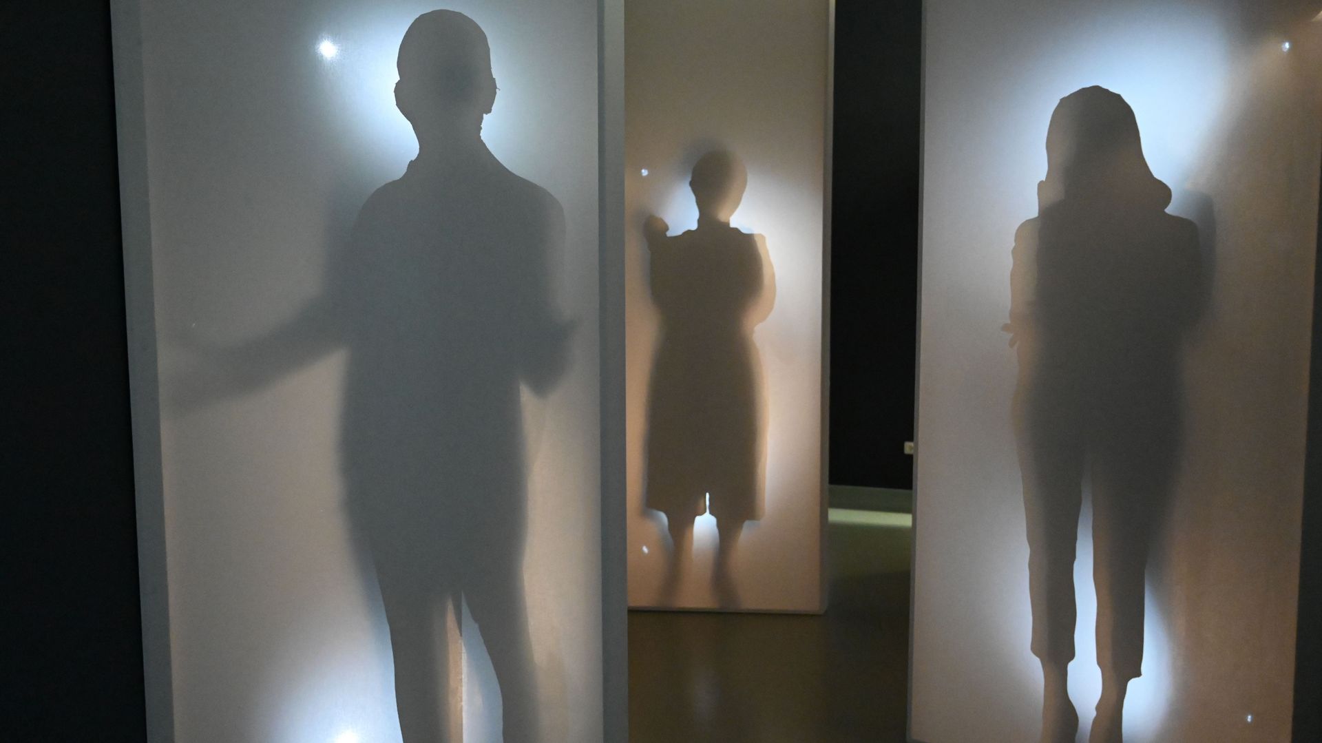 Foto aus der Ausstellung "Ankommen", zu sehen sind Schattenrisse von Menschen