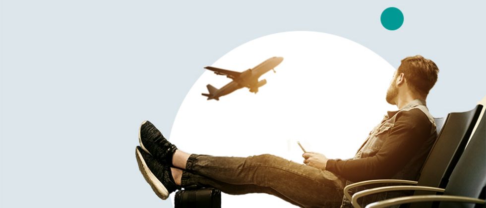 Vor einem großen grünen Punkt auf einer grauen Fläche ist die Warte-Sitzbank eines Flughafens zu erkennen. Ein junger Mann sitzt dort, seine Füße auf einem Koffer gelegt, und blickt nach oben zu einem Flugzeug.