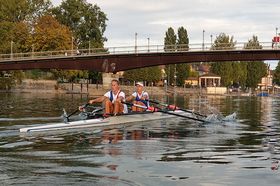 Rennruderboor mit zwei Fahrern auf dem Rhein vor der Konstanzer Fahrradbrücke.