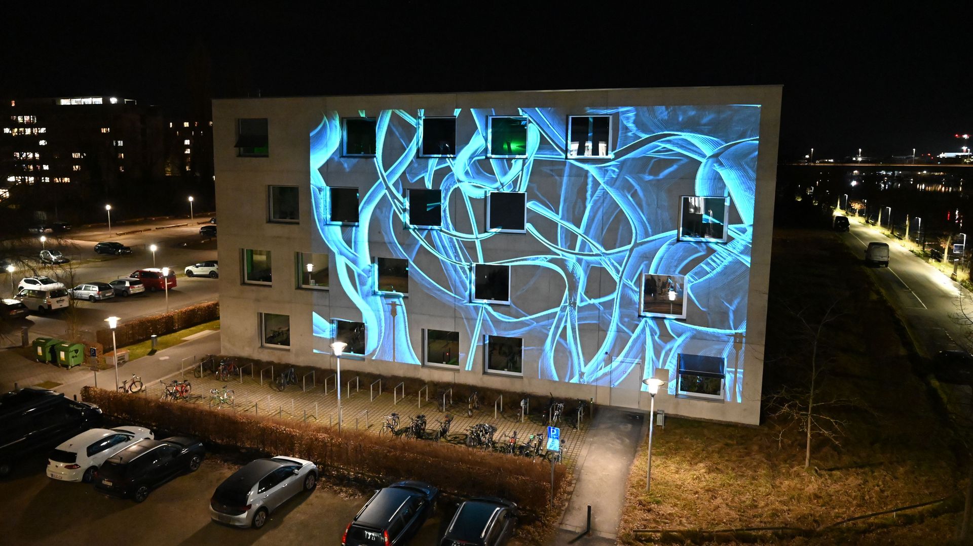 Zu sehen ist eine Fassaden-Bespielung bei Nacht auf dem Hochschulgebäude gegenüber dem L-Gebäude