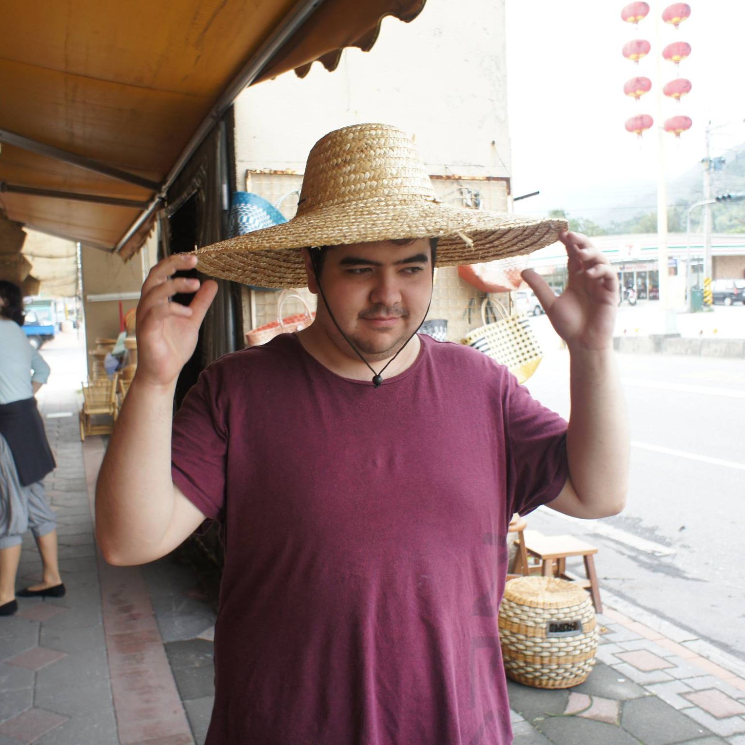 A photograph of former student Dorian Chou with a huge hat on his head