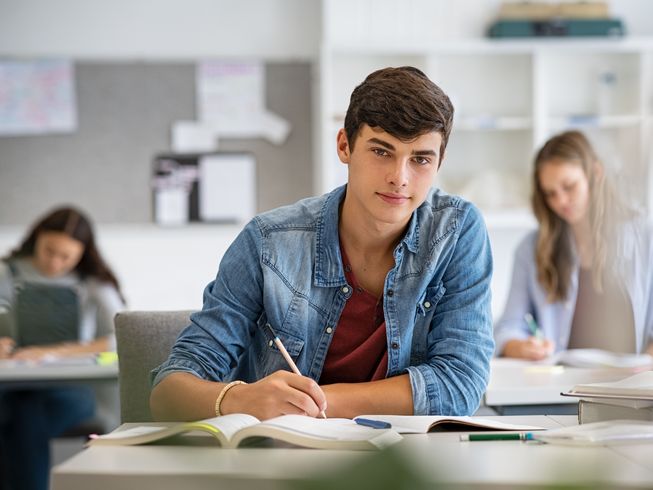 Junger Student während eines Seminars blickt in die Kamera.