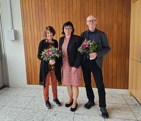 Gruppenbild Prof. Kleinfeld, Prof. Rein und Prof. Krekeler anlässlich der Wiederwahll. Kleinfeld und Krekeler halten Blumensträuße in der Hand