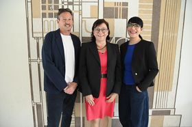 W4-Co-Geschäftsführer Markus Rhomberg, HTWG-Präsidentin und W4-Vorsitzende Prof. Dr. Sabine Rein und W4-Co-Geschäftsführerin Alexandra Hassler lächeln in die Kamera, im Hintergrund eine Wand einem Gemälde