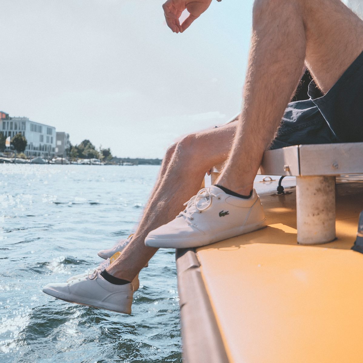 Studenten sitzen auf einem Boot auf dem Rhein und lassen ihre Beine über den Rand des Bootes baumeln
