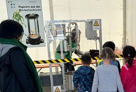 Kinder stehen vor einer Popcornmaschine