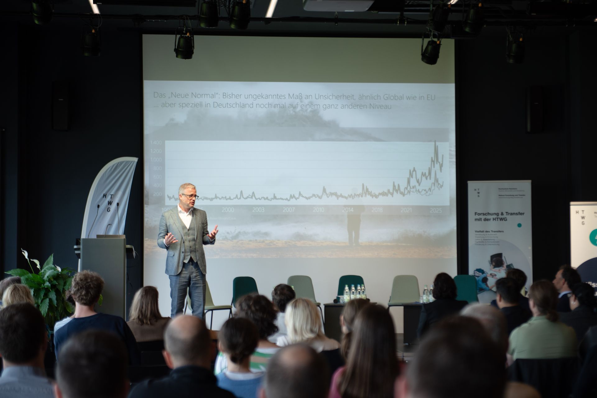 Prof. Dr. Guido Baltes steht auf der Bühne und hält eine Keynote.