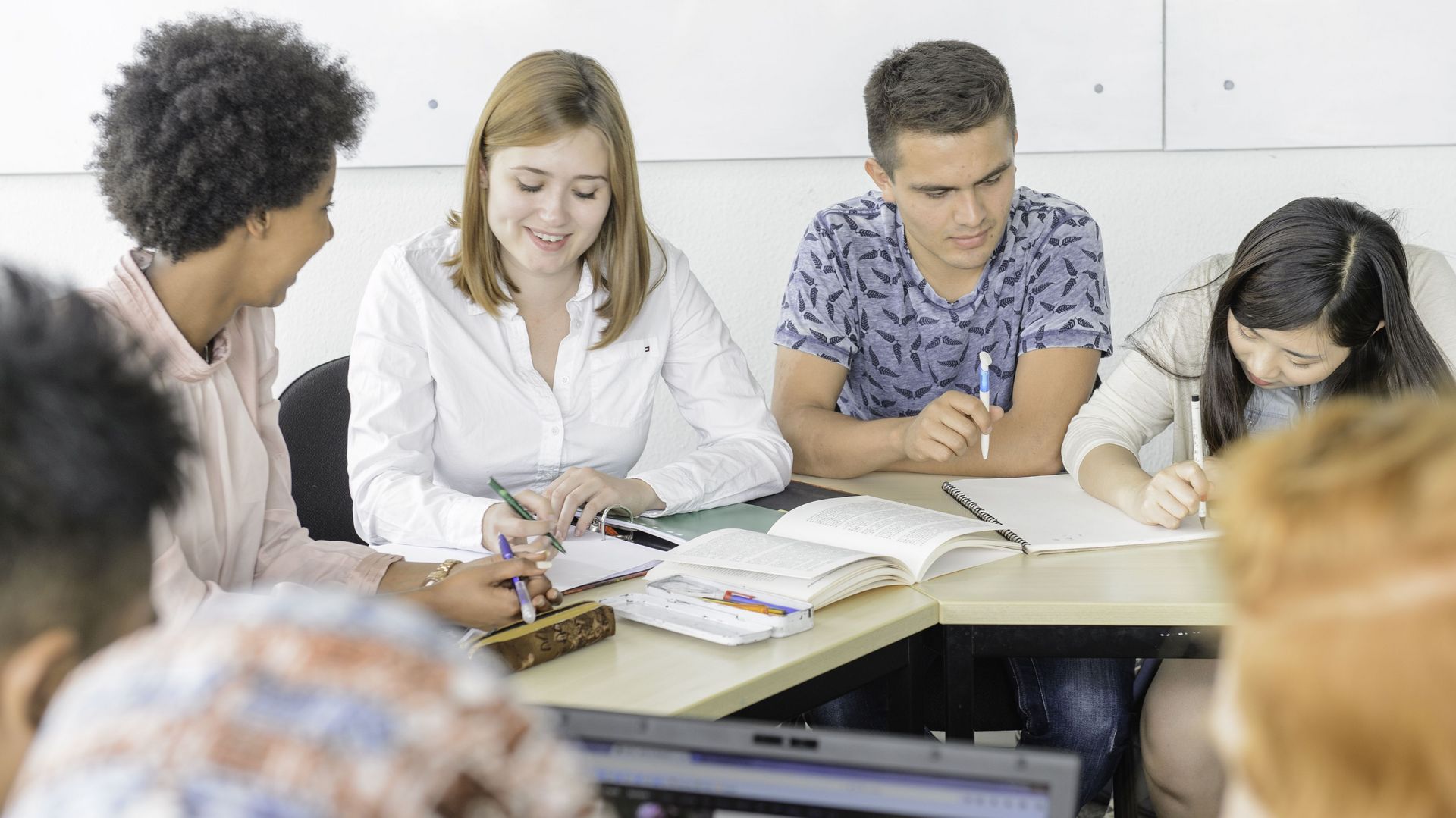 Eine Gruppe Studierender sitzen in einem Kurs und sind am lernen